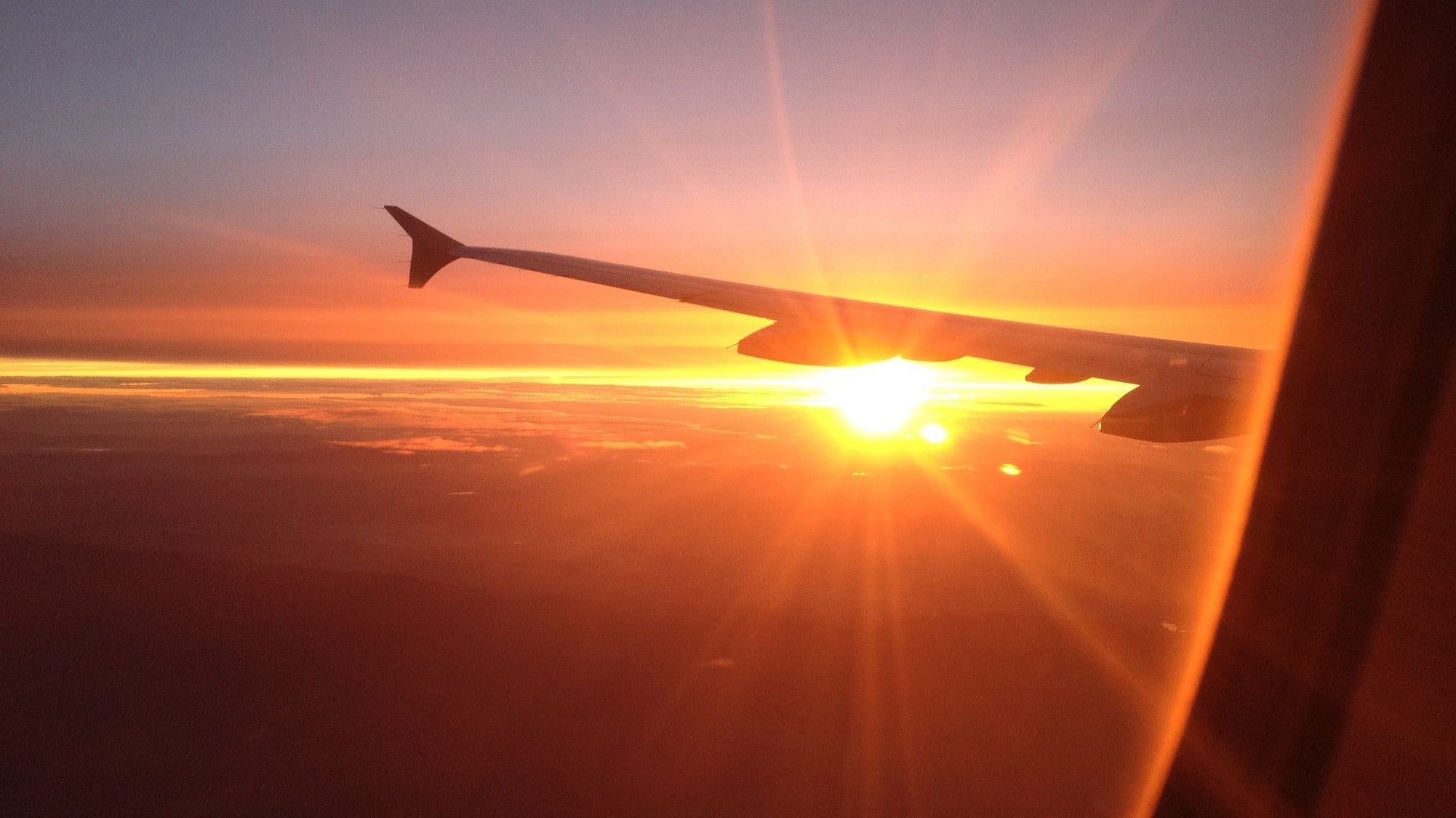 outside view from a window plane with the sun shining over a plane