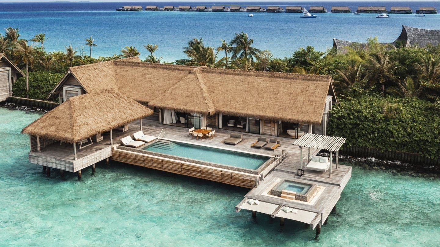View of private suite with pool, sunbeds, and jazzuzi with palm trees in the backround at Waldorf Astoria Maldives Ithaafushi.