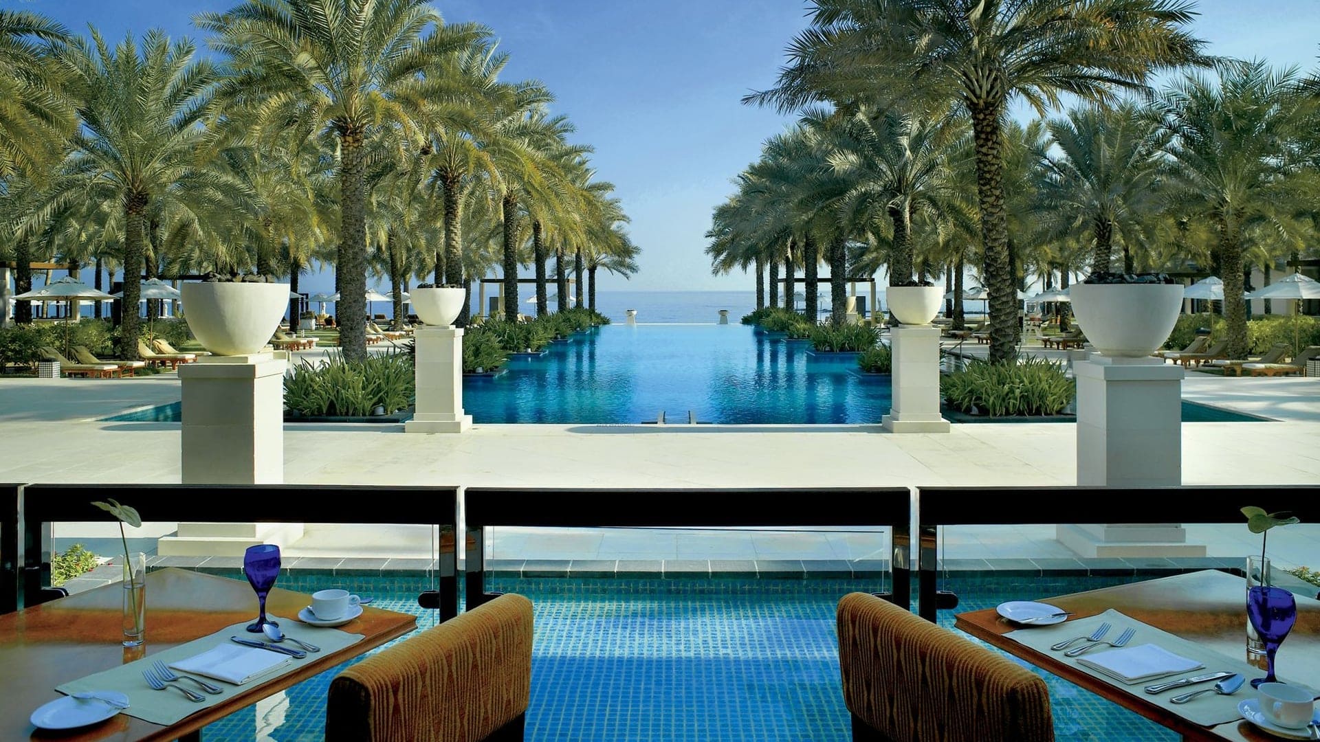 Outside pool and dining area at the al bustan palace at ritz carlton
