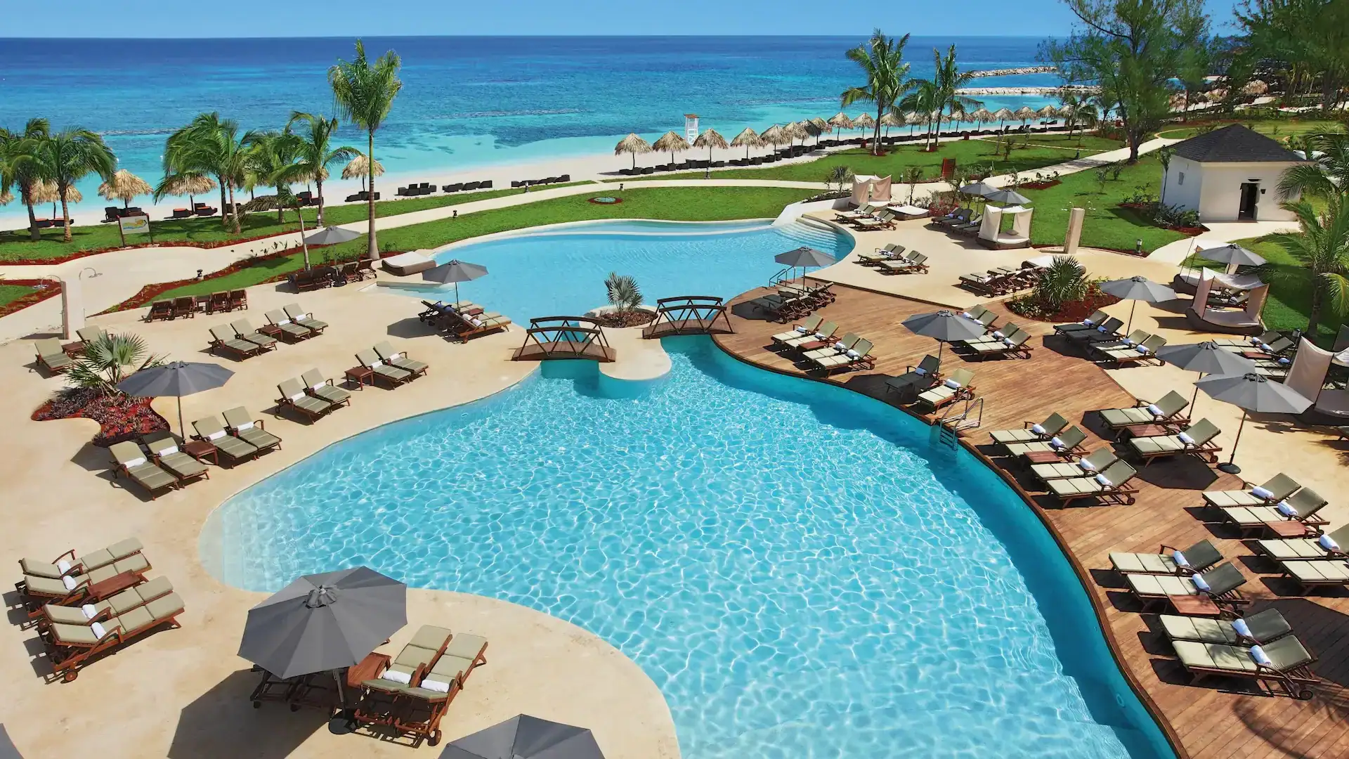 beach chairs around a swimming pool at the Secrets St. James Montego Bay