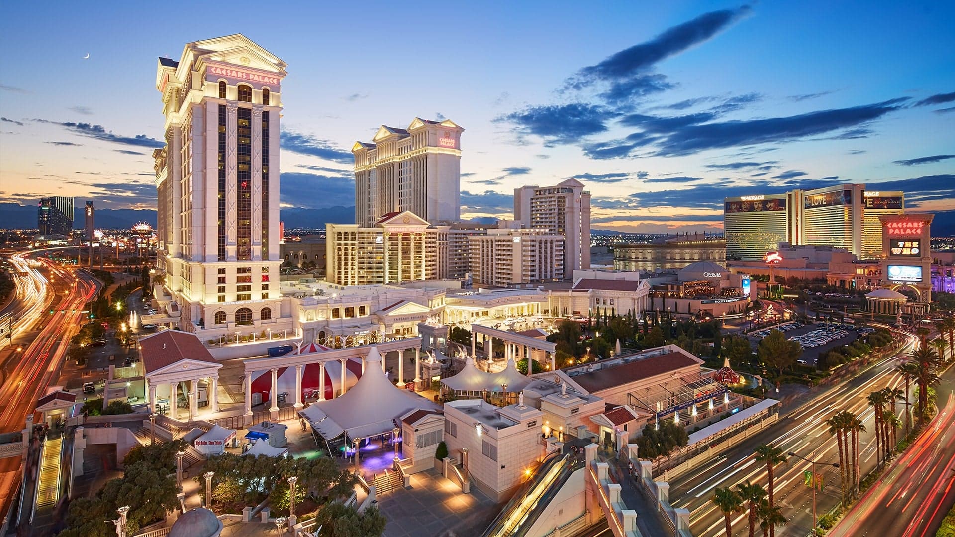 Large white biulding with text in red saying "CAESARS PALACE" with a very wide format taking up a lot of space.