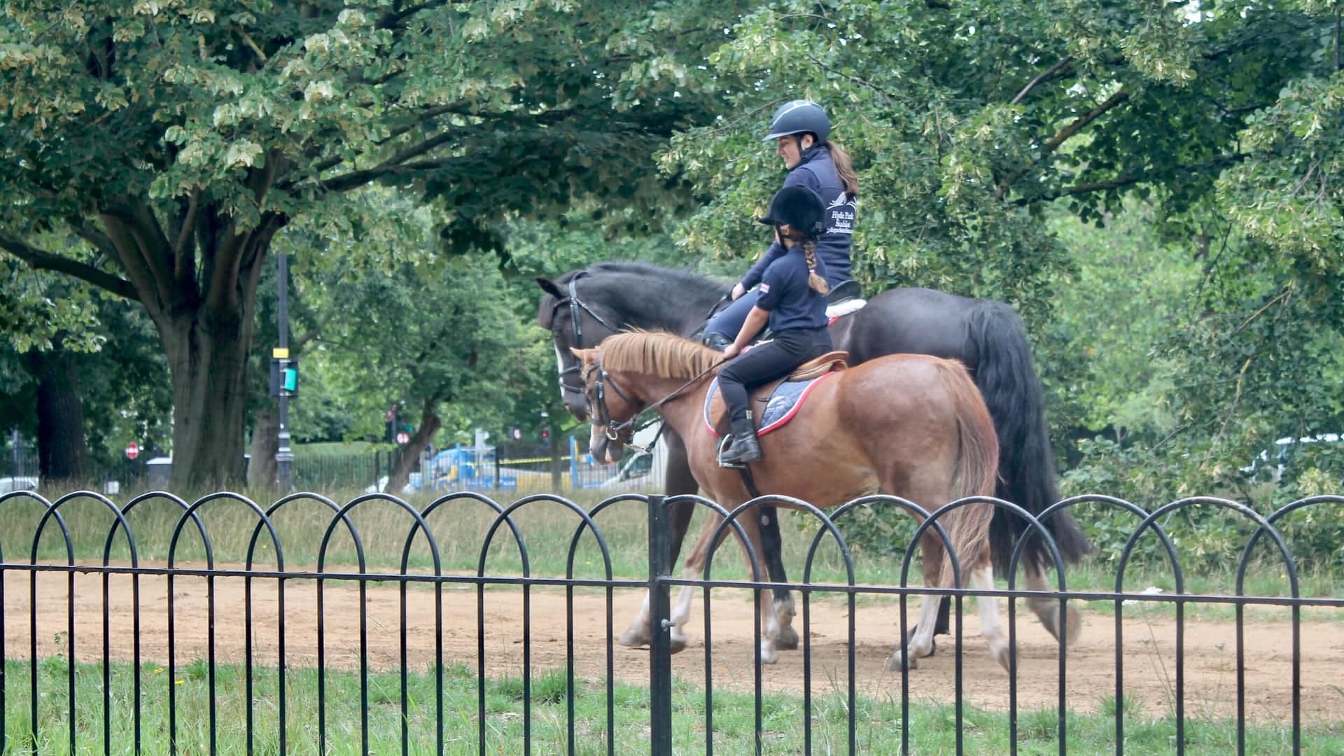 an instructor teaching a student how to ride a horse at Hyde Park Stables